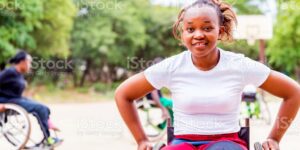 Young African woman smiling, seated in a wheelchair